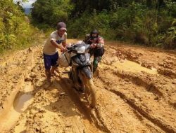 Siap Tanggap! Anggota Satgas TMMD 113/Kodim 1201 Bantu Warga Dorong Motor di Jalan Berlumpur